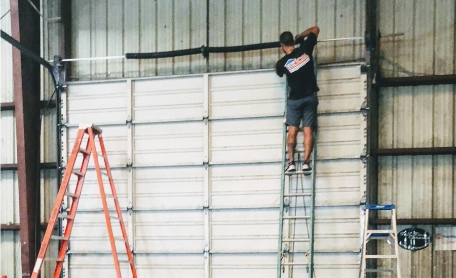 Commercial overhead door operator repair technician working.