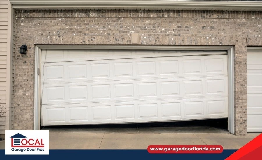 A close-up of the bottom panel of an old, white steel garage door showing significant rust spots and warping.