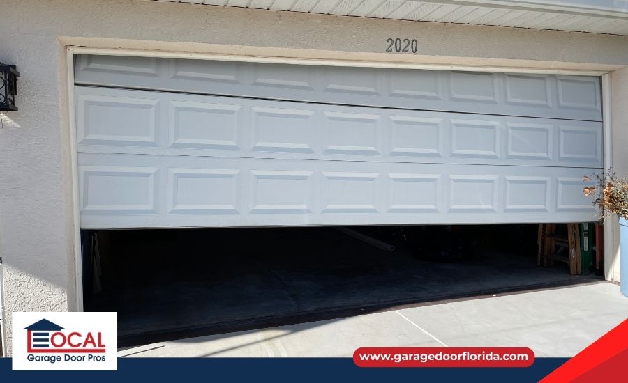 Close-up of a noisy, uneven garage door showing visible spring damage and tilted movement.