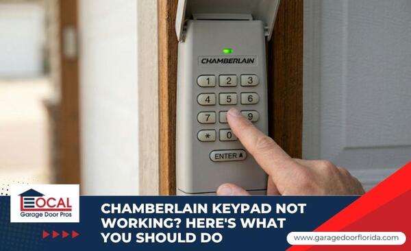 A person's finger pressing a button on a Chamberlain wireless garage door keypad mounted outside.