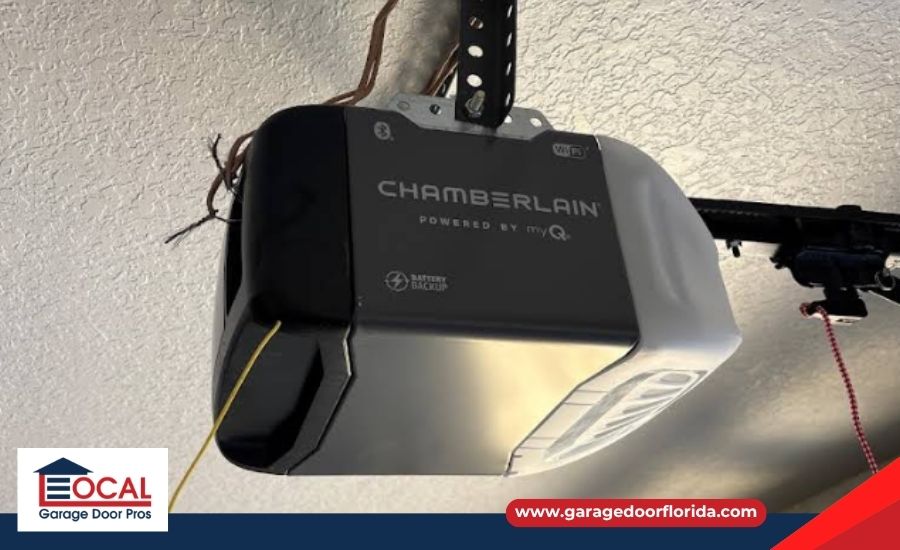 A Chamberlain garage door opener motor unit mounted on a textured ceiling.